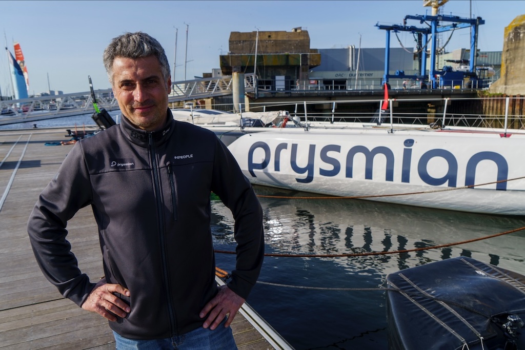 Giancarlo Pedote accanto all'IMOCA Prysmian nel porto di Lorient. Photo @Matteo Mangherini / NOESIS / Prysmian